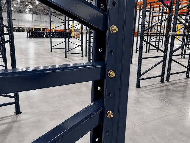 Navy bolt-together pallet rack upright with horizontal braces fastened by zinc-plated hex bolts in a warehouse